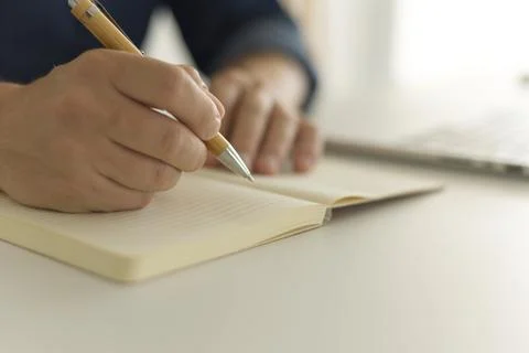 Man writing some notes at the desk while working Fotos de archivo