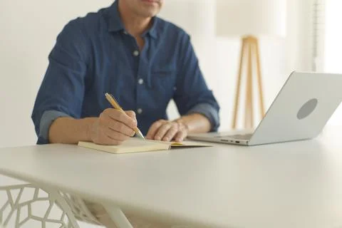 Man writing some notes at the desk while working Fotos de archivo