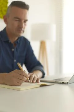Man writing some notes at the desk while working Fotos de archivo