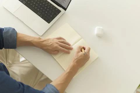Man writing some notes at the desk while working Fotos de archivo