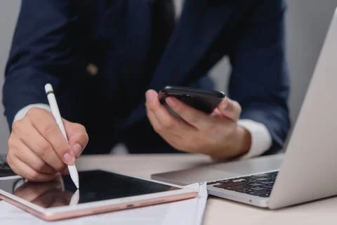 A man is writing on a tablet with a pen Stock Photos