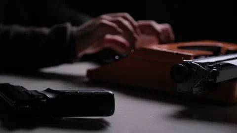 Man Writing on a Typewriter with a Gun on the Table at Night Stock Footage 318591051