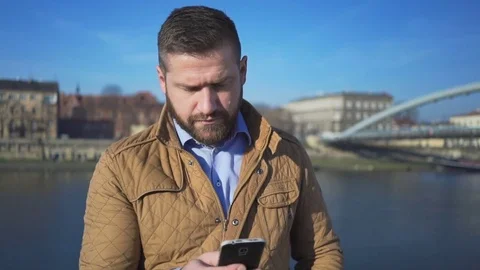 Man writing, typing sms message on smartphone on the background of the river 库存影片 72709550