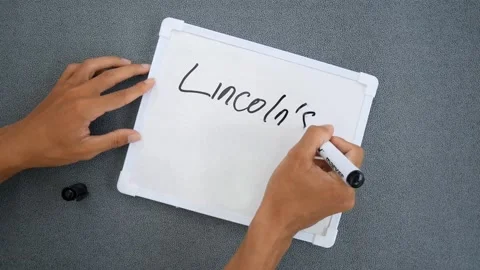 Man writing on a white board with the text Lincoln's Birthday. Stock-Footage 263932072