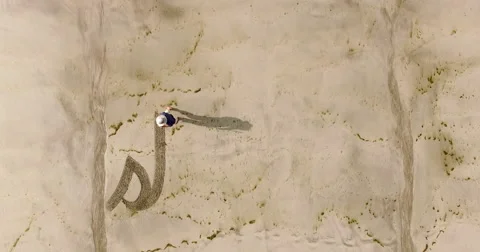 Man writing the word stillness in the sand Stock Footage