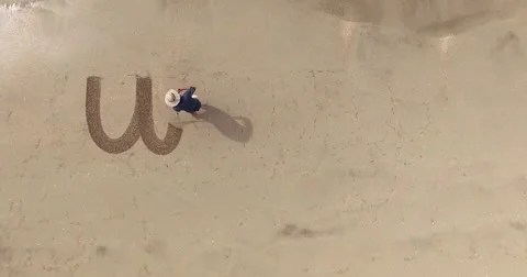 Man writing the word unity in the sand Stock Footage 65560856