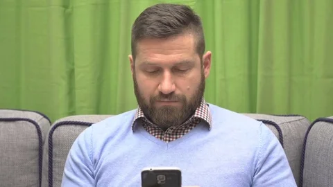 Man writwe sms, chatting on social media by smartphone, portrait close steadicam Vídeo Stock 73077299