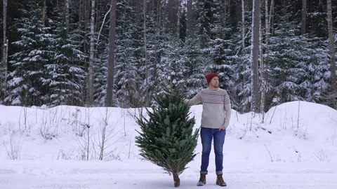 Man with a xmas tree in the winter forest 스톡 동영상 100353622