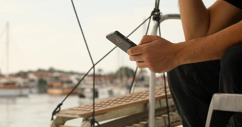 Man on yacht deck using smartphone 3 Stock Footage 129193976