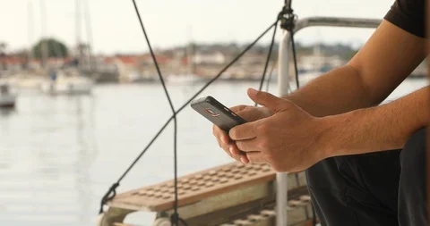 Man on yacht deck using smartphone 2 Stock Footage 129198047