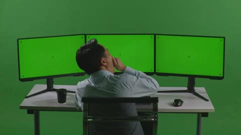 Man Yawning While Working With Mock Up Multiple Computer Monitor In Green Screen Stock Footage 249625774