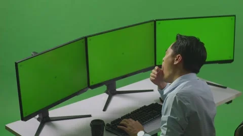 Man Yawning While Working With Mock Up Multiple Computer Monitor In Green Stock Footage 249634839