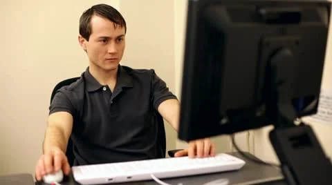 Man yawns while working at computer Stockbeeldmateriaal 10699309