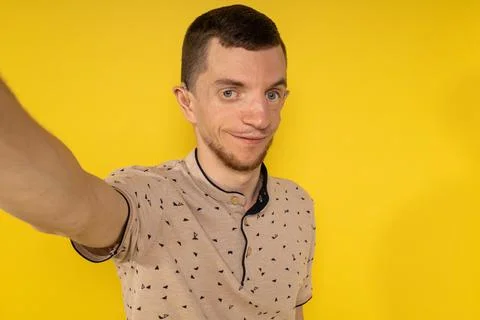 Man on yellow background taking selfies Stock Photos