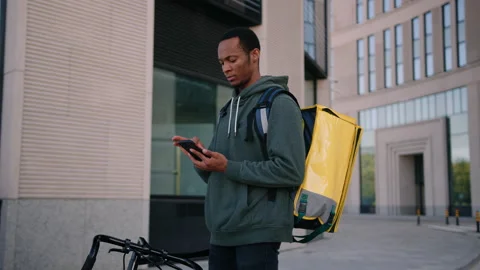 A man with a yellow backpack on the background of a modern city neighborhood Stock Footage 222892940