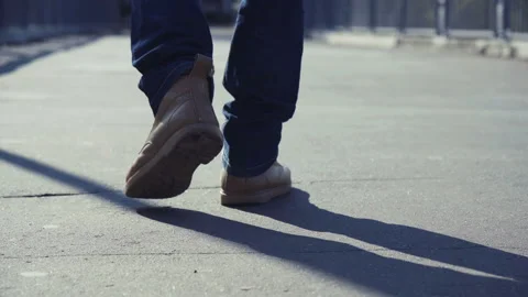 Man in yellow boots walks throughout urban Stock Footage 100561415