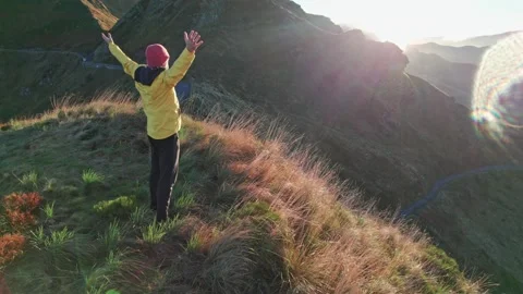 The man in the yellow jacket runs to the top of the mountain at sunrise, rais Video stock 219649937