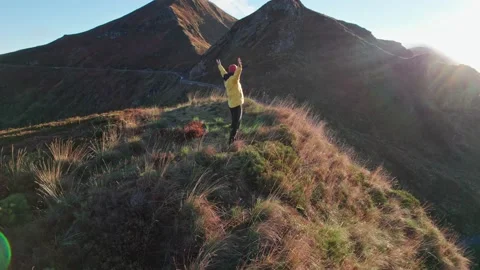 The man in the yellow jacket runs to the top of the mountain at sunrise, rais Stock Footage 219853630