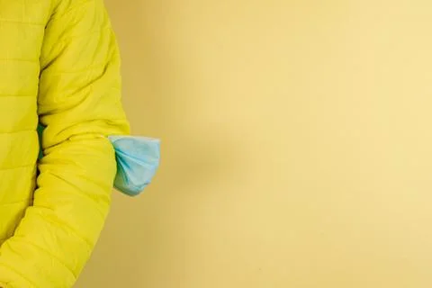 Man in yellow jacket is using a protective mask against corona virus on yello Stock Photos
