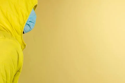 Man in yellow jacket is using a protective mask against corona virus on yello Stock Photos