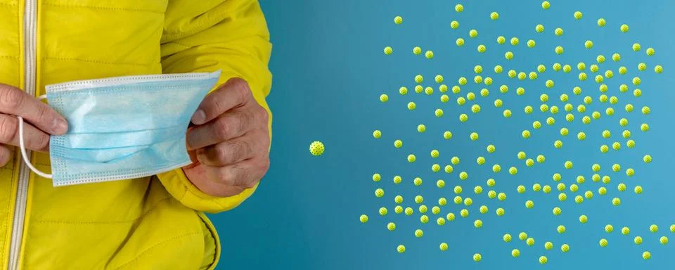 Man in yellow jacket is using a protective mask against corona virus on blue  Stock Photos