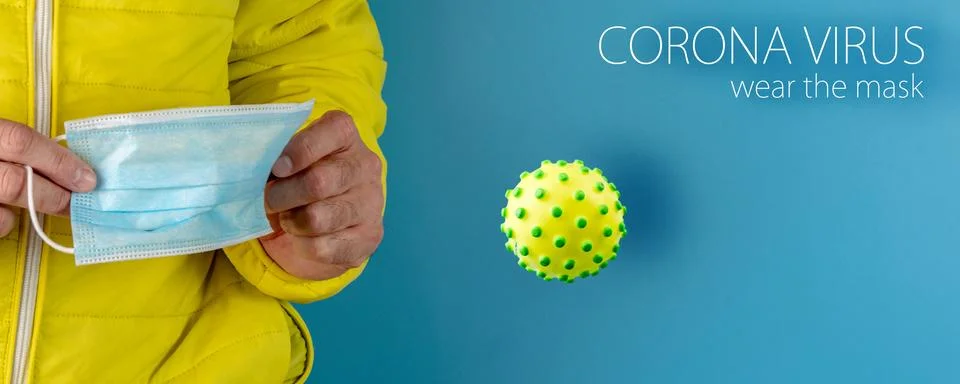 Man in yellow jacket is using a protective mask against corona virus on blue  Stock Photos