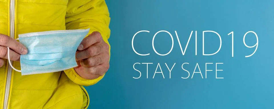 Man in yellow jacket is using a protective mask against corona virus on blue  Stock Photos