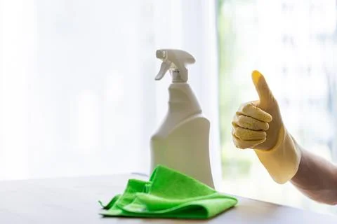 Man in yellow protective gloves dusting with cleaning agent Stock Photos