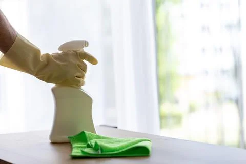 Man in yellow protective gloves dusting with cleaning agent Stock Photos
