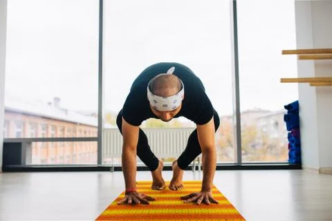 Man Yoga Practice Pose indoors, city panoramic view at background Stock Photos