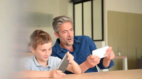 Man with young boy playing on smartphone Stock Footage 62683781