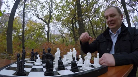 Man with young men playing chess in a park in autumn. Close-up. 库存影片 56314831