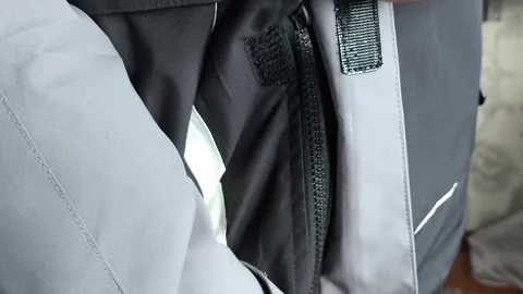 A man zips up a warm winter jacket in close-up. Down jacket for cold weather. Stock Footage 325034074