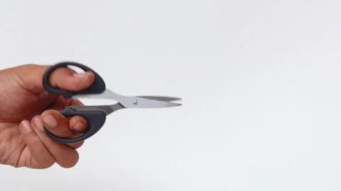Man&amp;#039;s hand making a cutting motion with a pair of scissors Stock Footage 339772208