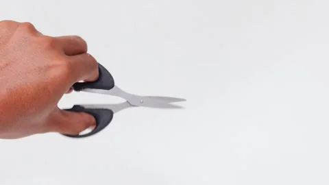 Man&amp;#039;s hand making a cutting motion with a pair of scissors Stock Footage 339772222