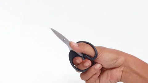 Man&amp;#039;s hand making a cutting motion with a pair of scissors Stock Footage 339772224
