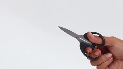 Man&amp;#039;s hand making a cutting motion with a pair of scissors Stock Footage 339772225