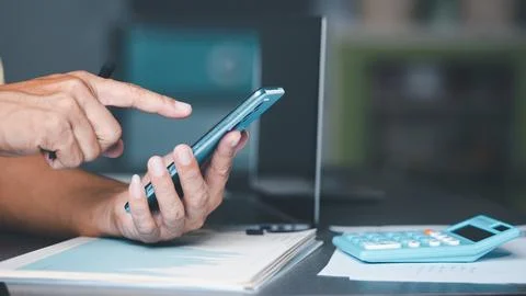 Management is checking the information via a smartphone. Concept of handlin.. Stock Photos