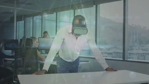 Manager activating VR headset, showing tech demo at table as network overlay Stock Footage 334115730