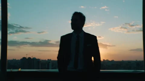 Manager after a working day against the backdrop of the city at sunset Stock Footage 131400462