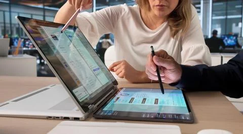 Manager And Assistant Review Digital Files Using Laptop For Smooth Workflow. Stock Photos