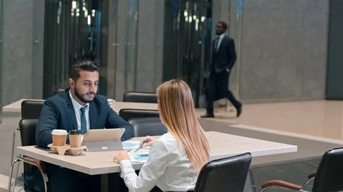 Manager and his partner sitting on the table in cafe and discussing diagram Vidéo 100903883