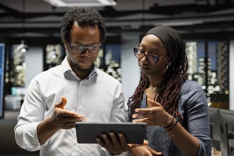 Manager and intern brainstorming in office, reviewing AI system metrics Stock Photos