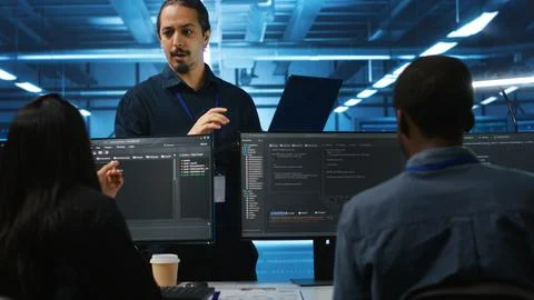 Manager and IT support specialists working together, supervising server rows 库存照片