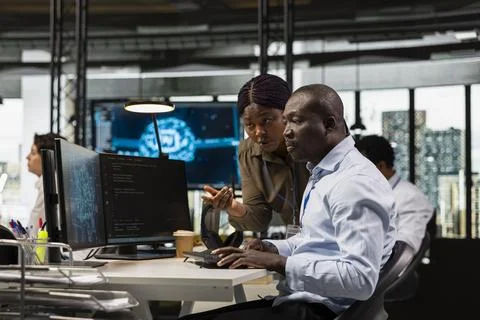 Manager and IT worker testing AI machine learning algorithms at work Stock Photos