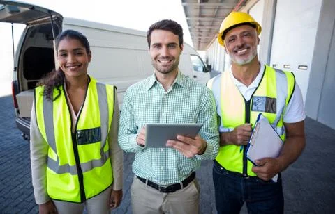 Manager and warehouse workers standing with digital tablet and clipboard Foto stock