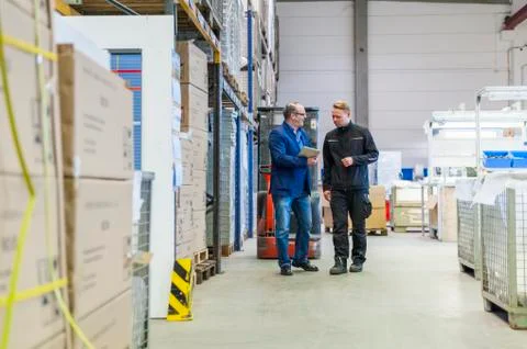 Manager and warehouseman dicussing logistics in storage Stock Photos