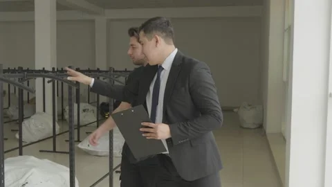 Manager and Worker Inspecting Empty Retail Store Space Vidéo 346229053