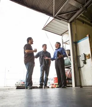 Manager and workers talking at warehouse loading dock Stock Photos