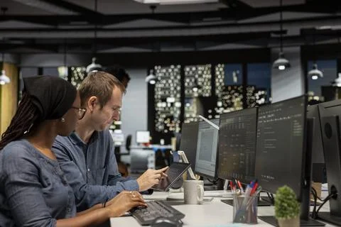 Manager assisting tech startup engineer coding neural network algorithms Stock Photos